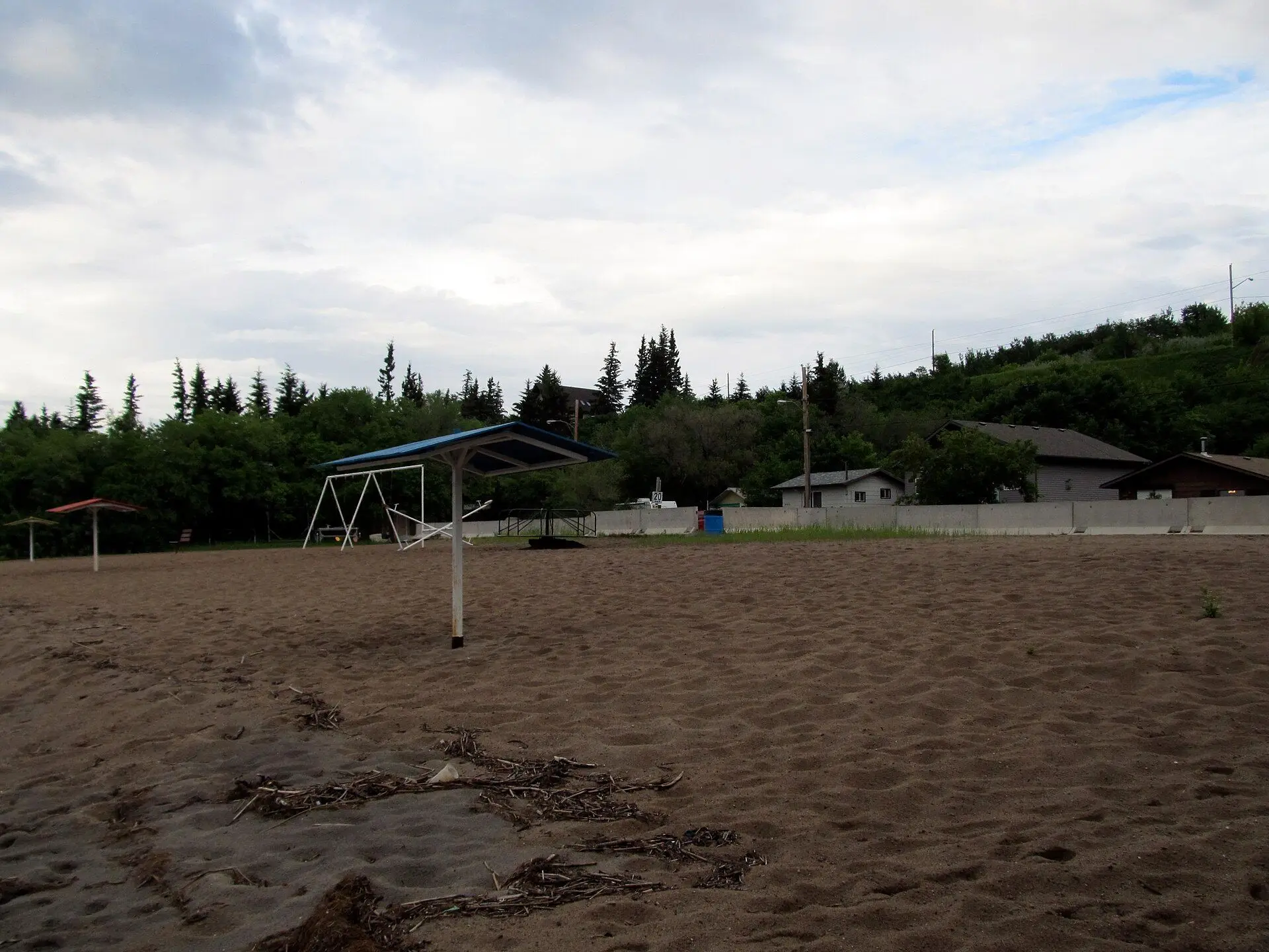 Sandy beach with shade shelters and swing set